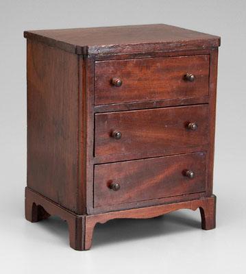 Appraisal: Miniature mahogany chest three dovetailed drawers above bracket feet British