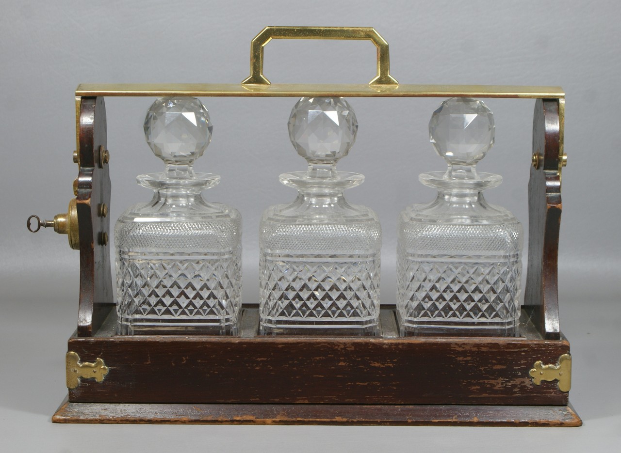 Appraisal: English mahogany framed tantulus cut crystal bottles marked Betjemann's Patent