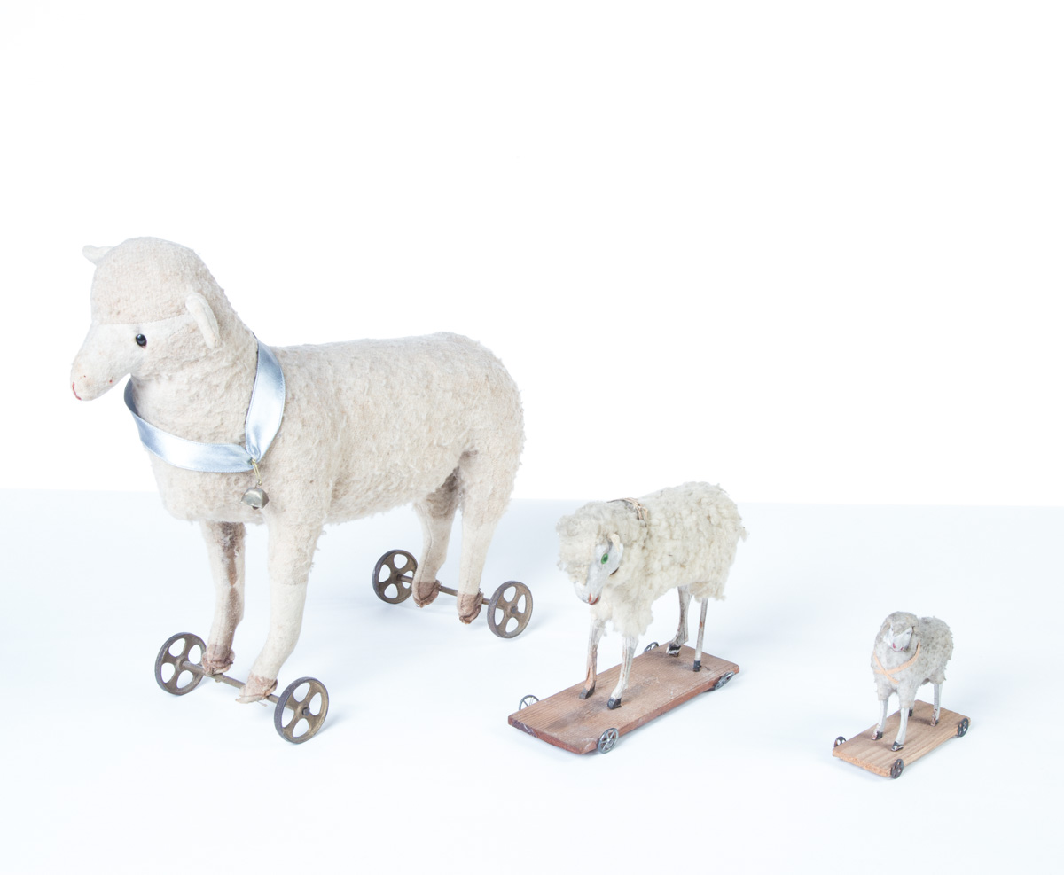 Appraisal: THREE SHEEP PULL TOYS Circa Cloth bodies glass eyes and