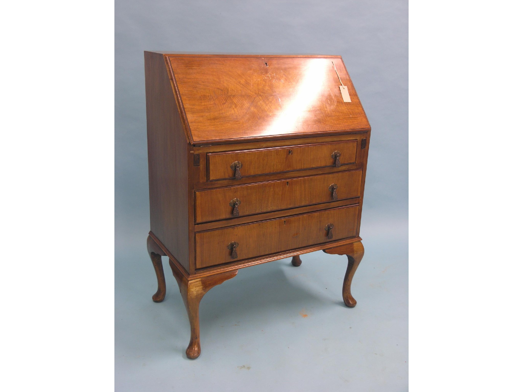 Appraisal: A burr walnut veneered bureau enclosed fittings above three long