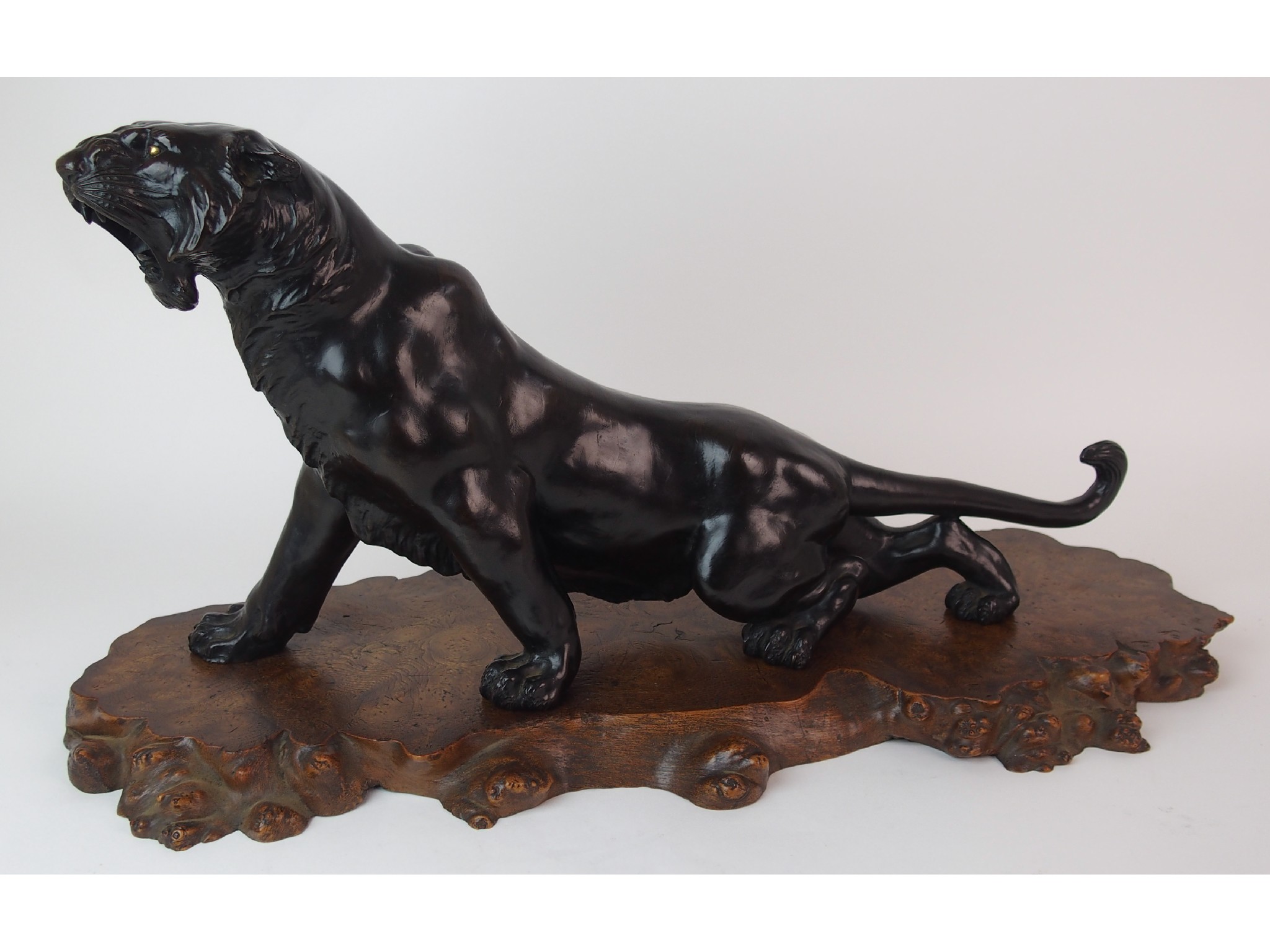 Appraisal: A Japanese bronze golden eye tigermodelled in crouched roaring position