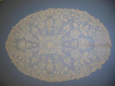 Appraisal: AN OVAL EMBROIDERED LACE PANEL with floral sprigs on net