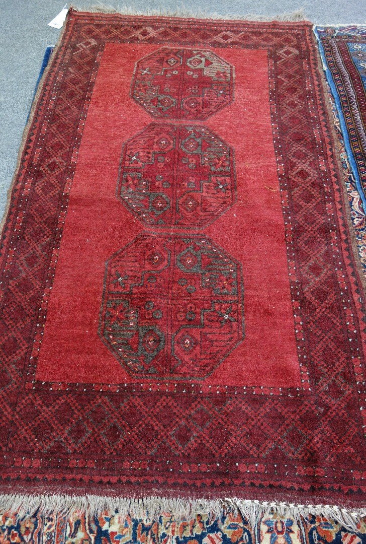 Appraisal: An Afghan rug the plain madder field with three bold