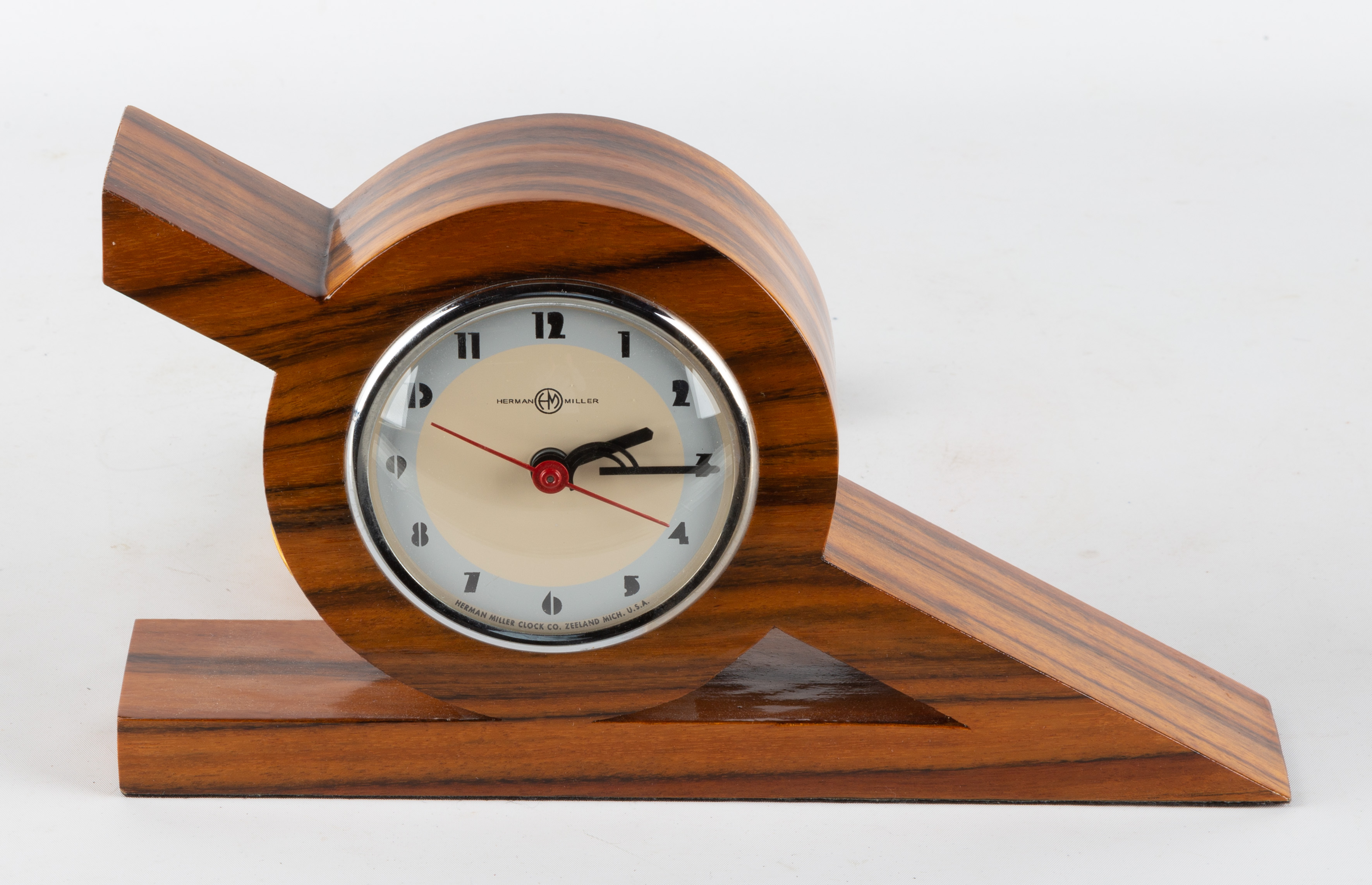 Appraisal: GILBERT ROHDE STYLE CLOCK Wood veneer and chrome