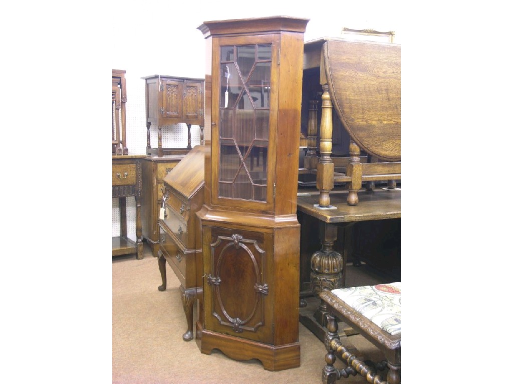 Appraisal: A small floor-standing mahogany corner cabinet astragal glazed door enclosing