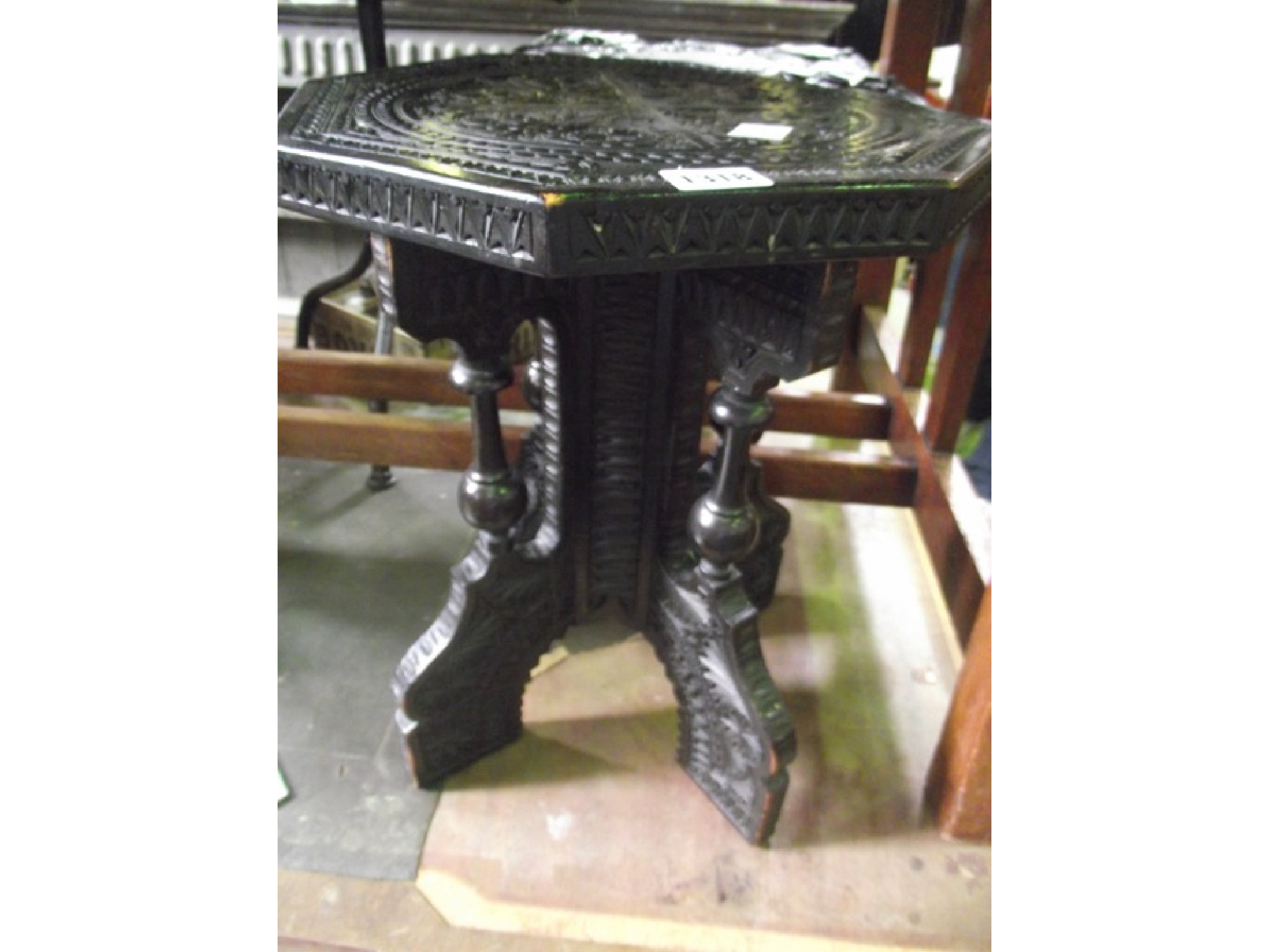 Appraisal: A small ebonised chip carved occasional table of octagonal form