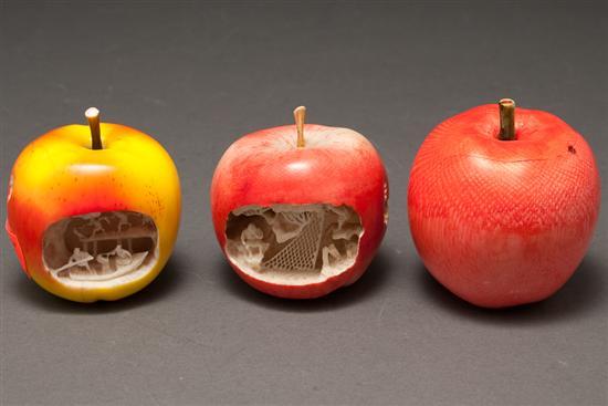 Appraisal: Two Japanese carved and polychromed ivory apples with interior village