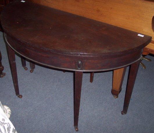 Appraisal: A George III mahogany semi-circular table with folding top on