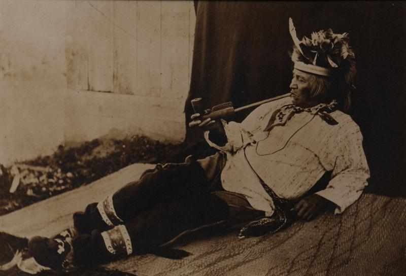 Appraisal: UNKNOWN C RECLINING INDIAN SMOKING A PIPE Gold-toned platinum print