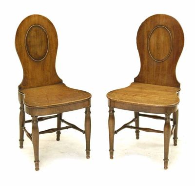 Appraisal: A near pair of late George III mahogany hall chairs