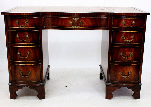 Appraisal: A GEORGIAN STYLE MAHOGANY SERPENTINE FRONTED PEDESTAL DESK with brown