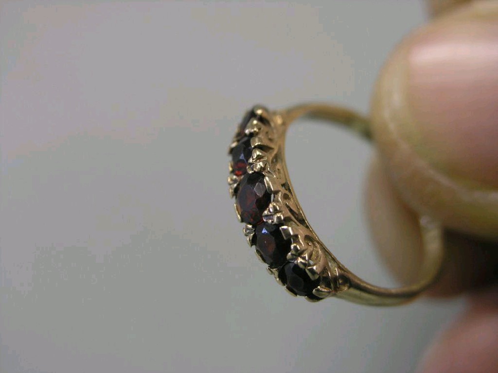 Appraisal: A ct gold ring five red stones within carved claw