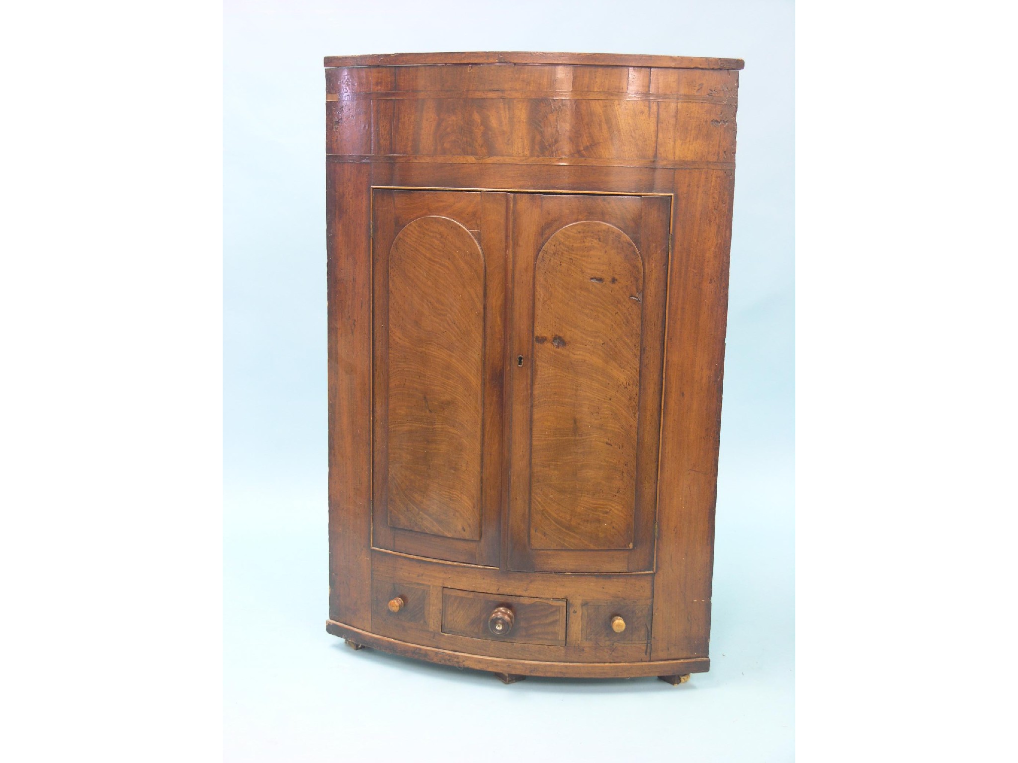 Appraisal: An early Victorian mahogany corner cupboard bow-fronted and enclosed by