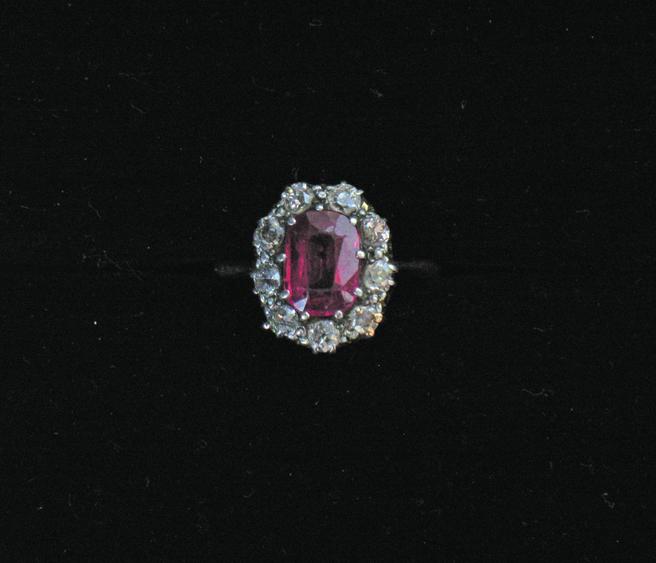 Appraisal: A DIAMOND CLUSTER RING the central oval cushion-cut coloured stone