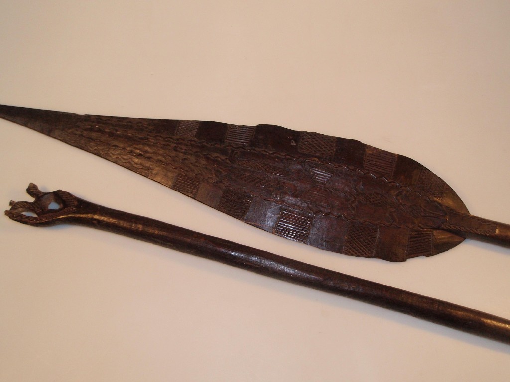 Appraisal: A pair of tribal carved hard wood paddle spears