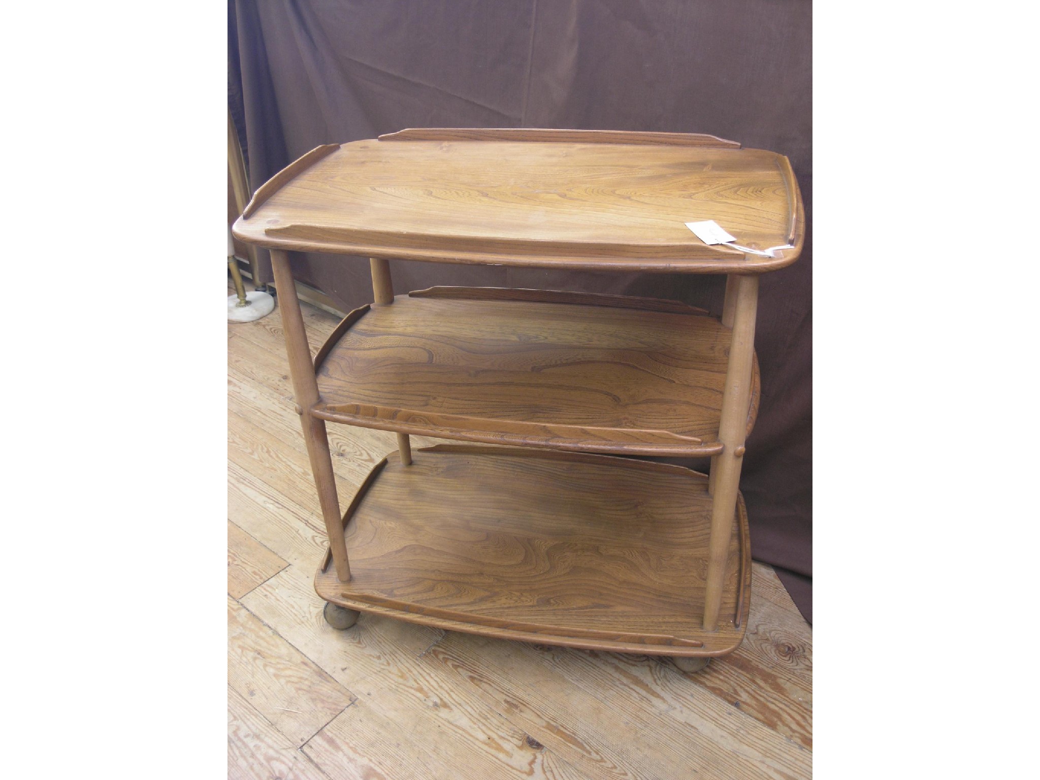 Appraisal: An Ercol golden elm three-tier trolley