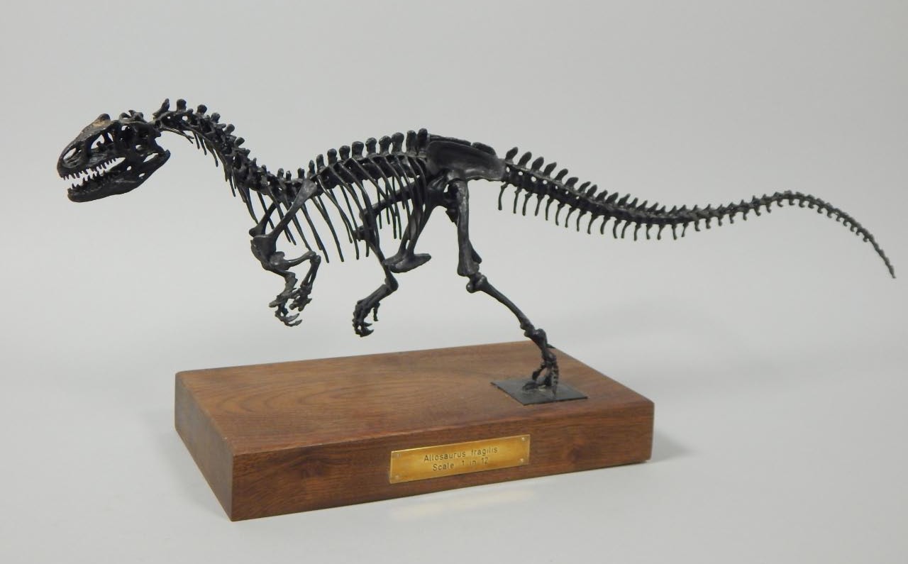 Appraisal: A metal scale model of an Allosaurus on a mahogany