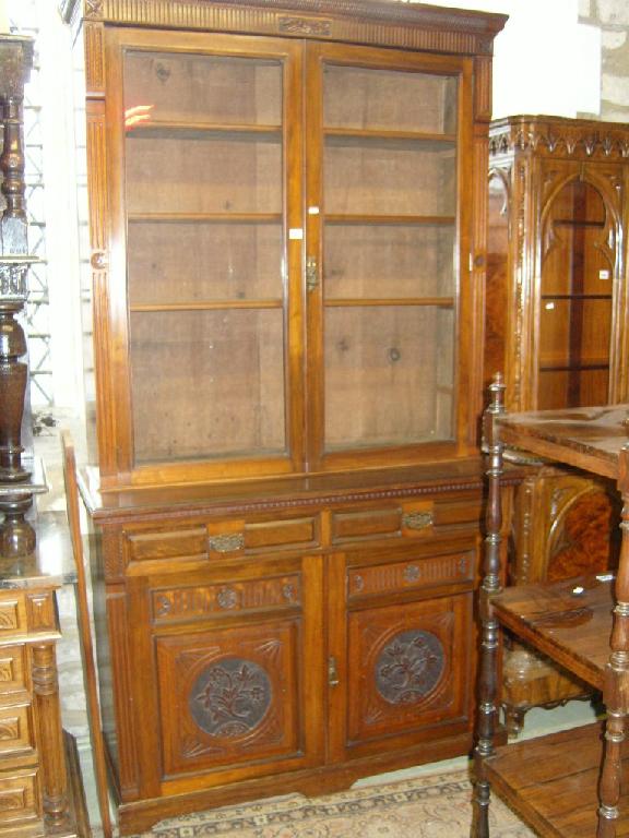 Appraisal: A late Victorian walnut bookcase cabinet the upper section enclosed