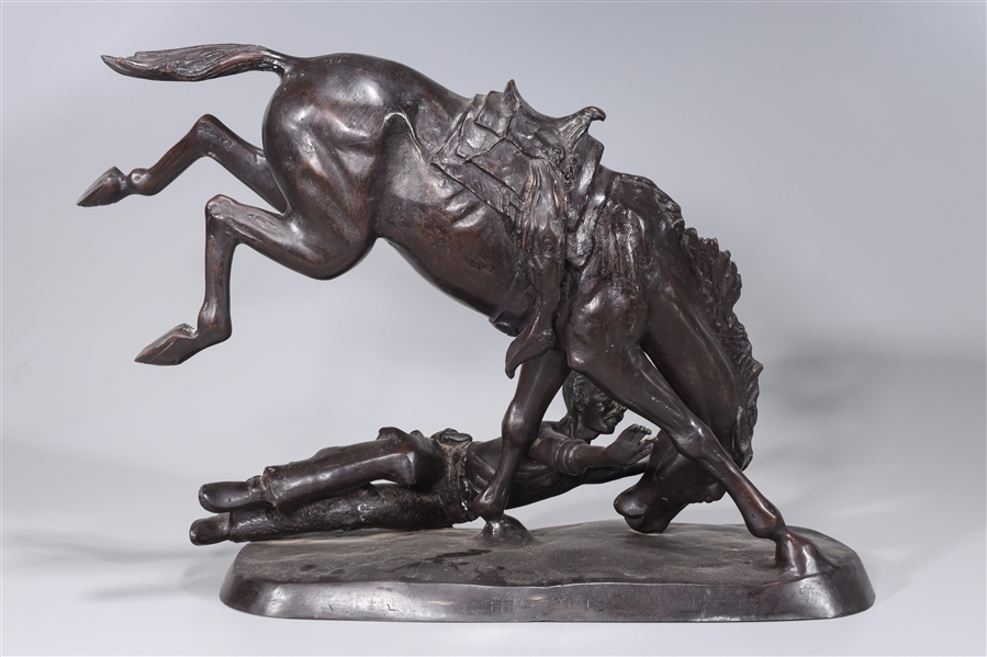 Appraisal: Bronze statue of horse and bucked rider with illegible signature