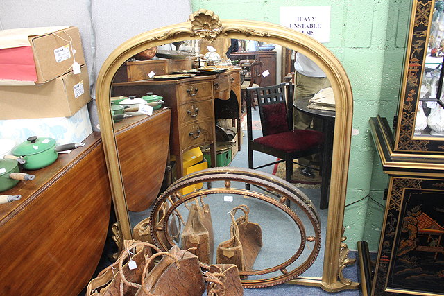 Appraisal: A PAIR OF GILT FRAMED OVERMANTLE MIRRORS with arching tops