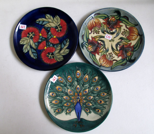 Appraisal: THREE MOORCROFT POTTERY PLATES hand painted under glaze in peacock