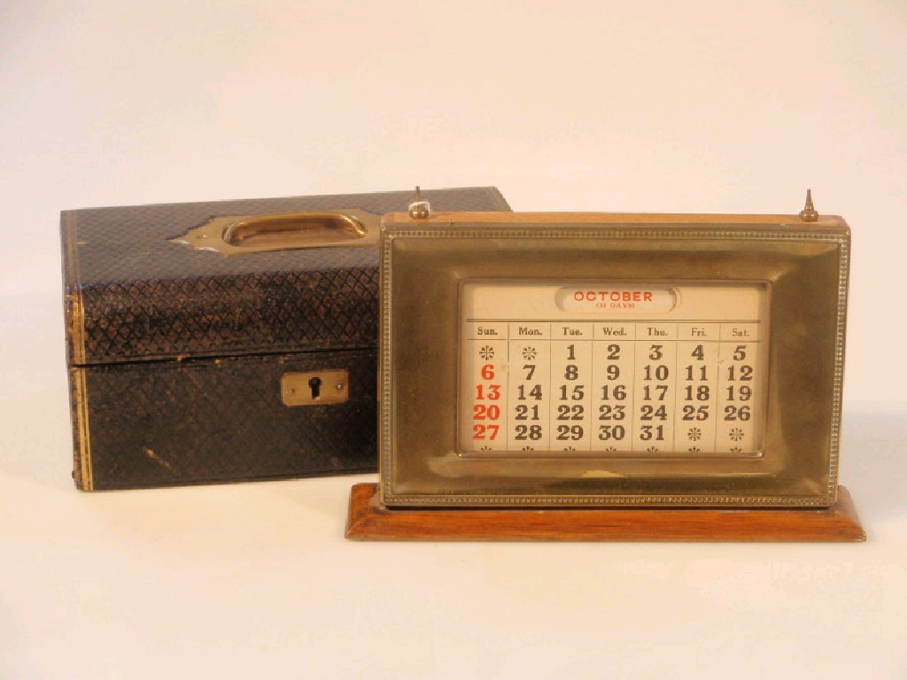 Appraisal: An early thC brass faced oak desk calendar previously plated