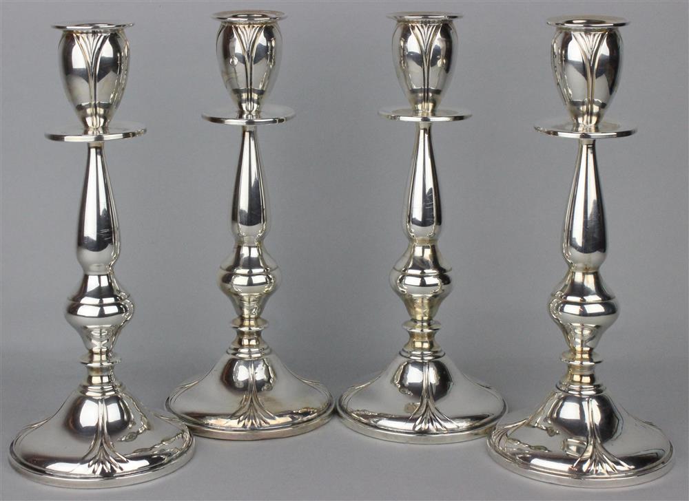 Appraisal: SET OF FOUR LOTUS WEIGHTED CANDLESTICKS with stylized lotus flower