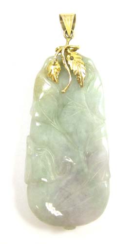 Appraisal: JADE AND FOURTEEN KARAT GOLD PENDANT with a carved green