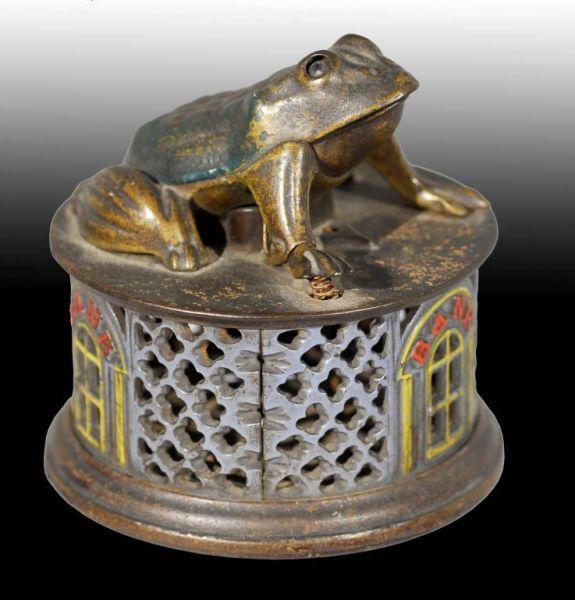 Appraisal: Cast Iron Frog on Lattice Mechanical Bank Description Manufactured by