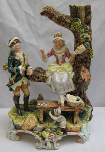 Appraisal: A STAFFORDSHIRE GLAZED PORCELAIN FIGURAL GROUP having a pretty lady