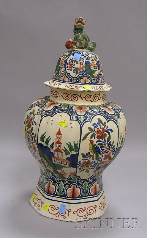 Appraisal: Continental Tin-glazed Pottery Covered Urn polychrome decorated reserves with buildings