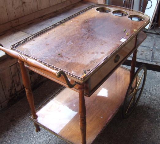 Appraisal: A walnut and metal mounted drinks trolley with bottle stands