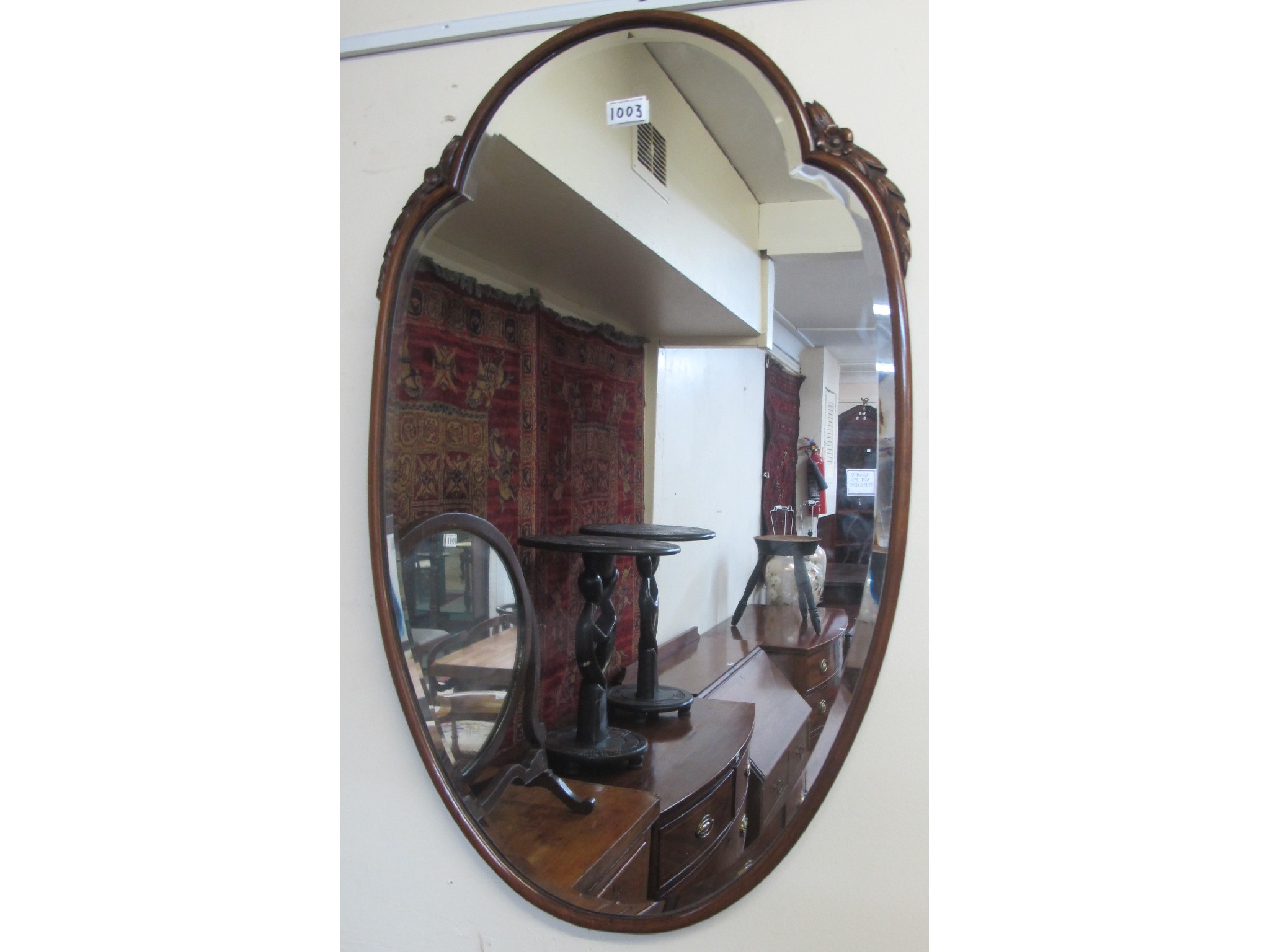 Appraisal: A mahogany framed wall mirror with floral carving to the