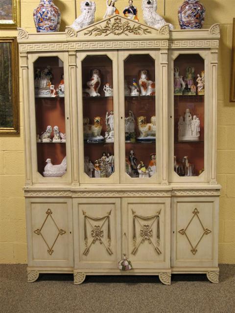 Appraisal: NEOCLASSICAL STYLE CREAM PAINTED BOOKCASE th century the cornice carved