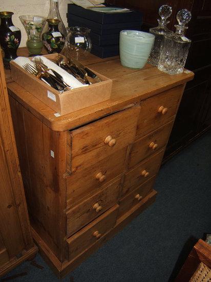 Appraisal: An antique pine chest of eight short drawers standing on