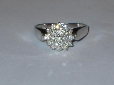 Appraisal: A DIAMOND CLUSTER RING comprising nineteen brilliant cut diamonds claw