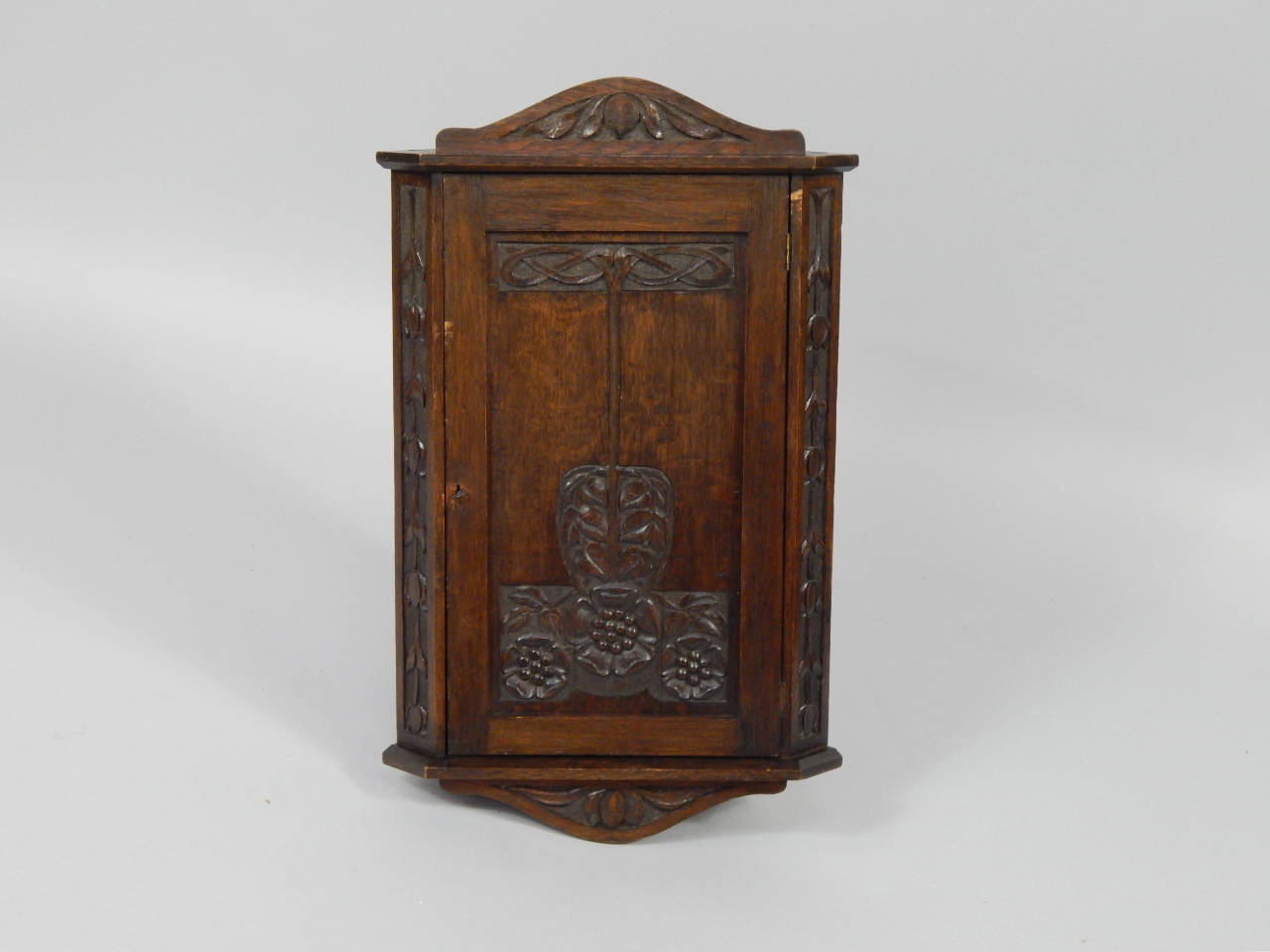 Appraisal: An Art Nouveau oak hanging corner cupboard carved with tulips