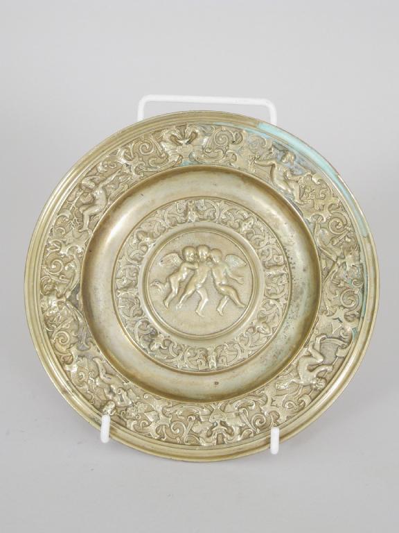 Appraisal: A brass circular small Alms Dish with frieze of cherubs