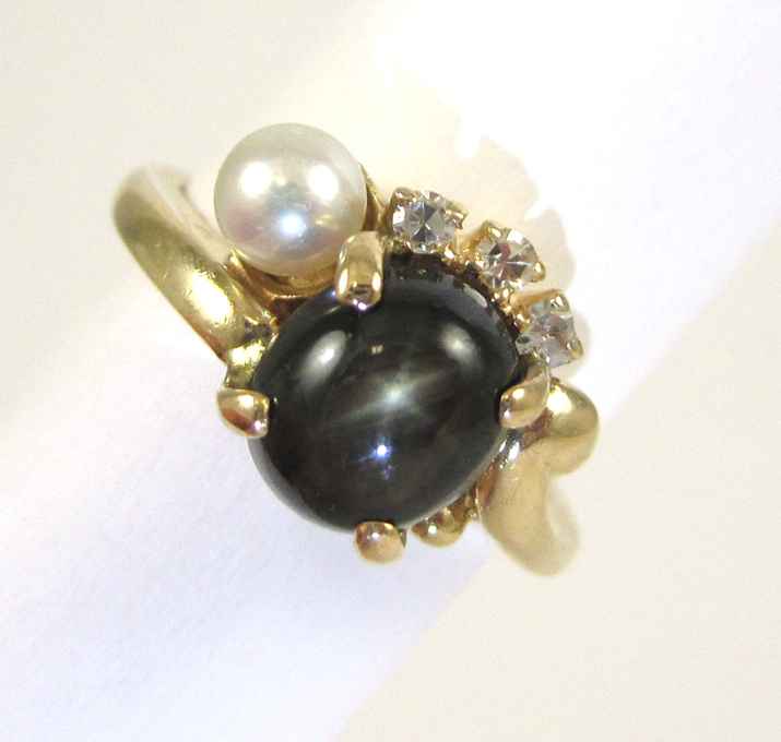 Appraisal: BLACK STAR SAPPHIRE PEARL AND DIAMOND RING The k yellow