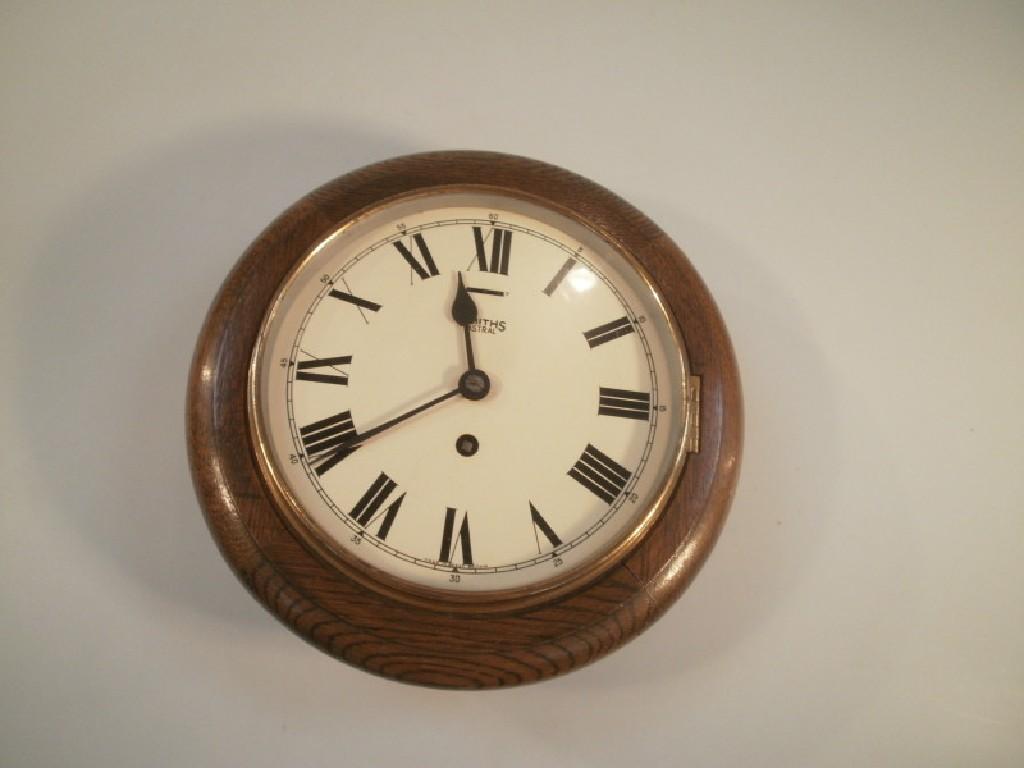 Appraisal: A Smiths oak cased circular wall clock the enamel dial