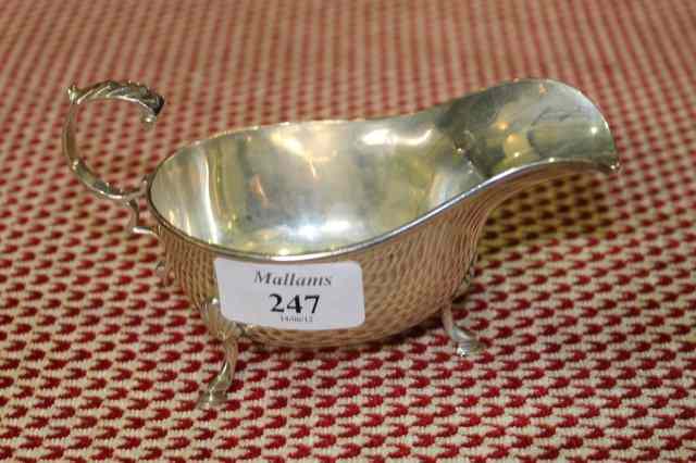 Appraisal: A GEORGIAN STYLE SILVER SAUCE BOAT on three cabriole supports