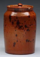 Appraisal: COVERED GLAZED REDWARE JAR The brown spotted orange brown glaze