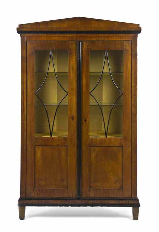 Appraisal: A Biedermeier Corner Cabinet having a peaked crest over two