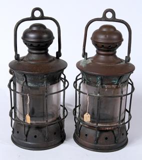 Appraisal: A pair of nautical brass lanterns with protection brackets which