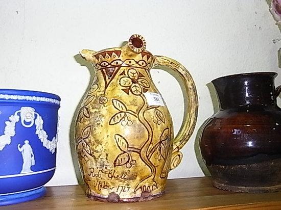 Appraisal: A SLIPWARE PUZZLE JUG with sgraffito decoration bearing an inscription