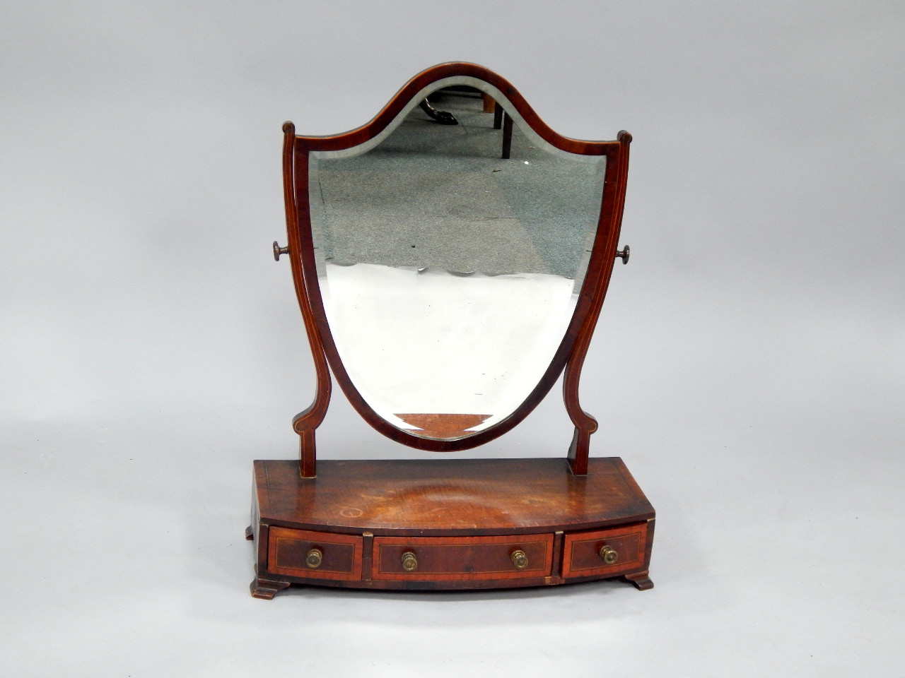 Appraisal: A Sheraton crossbanded mahogany dressing table mirror with bevelled shield