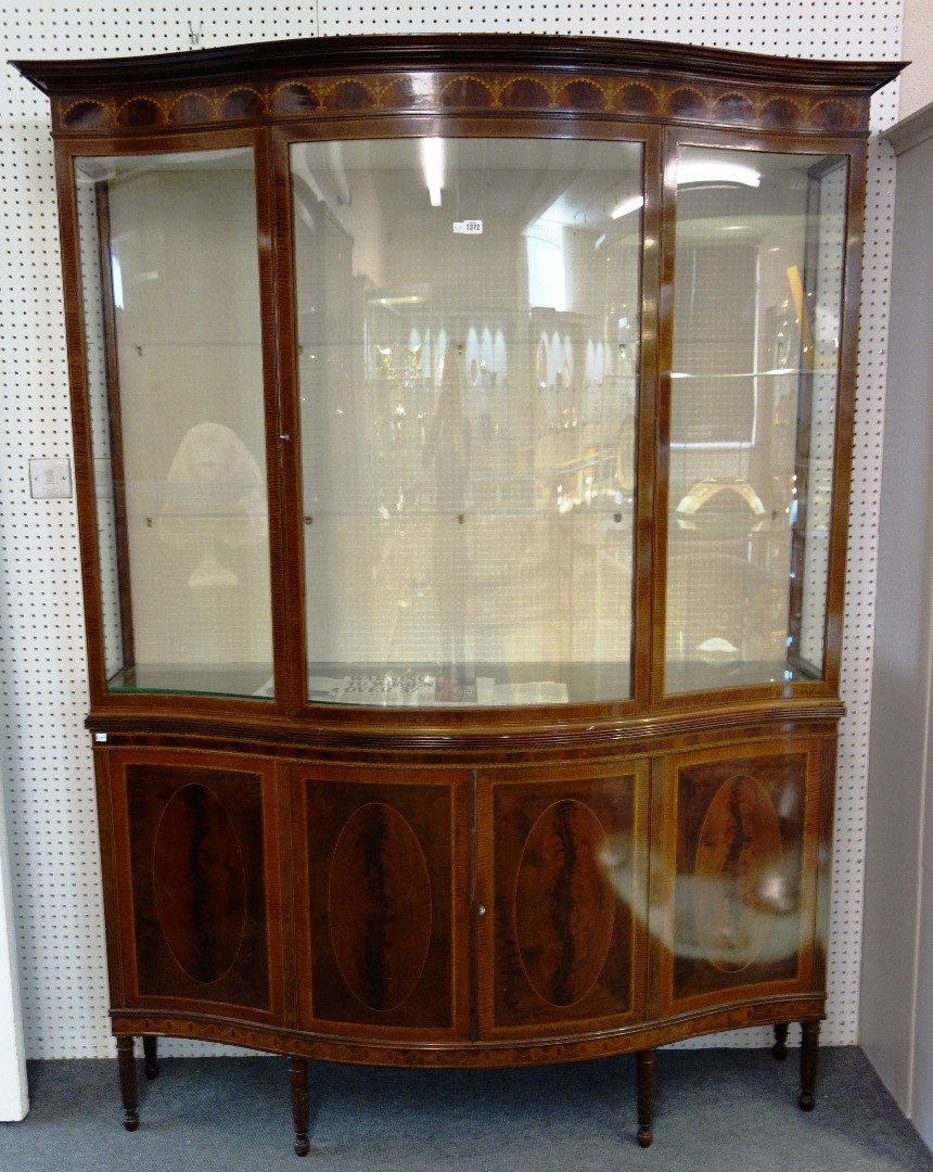 Appraisal: A late th century marquetry inlaid mahogany serpentine display cabinet