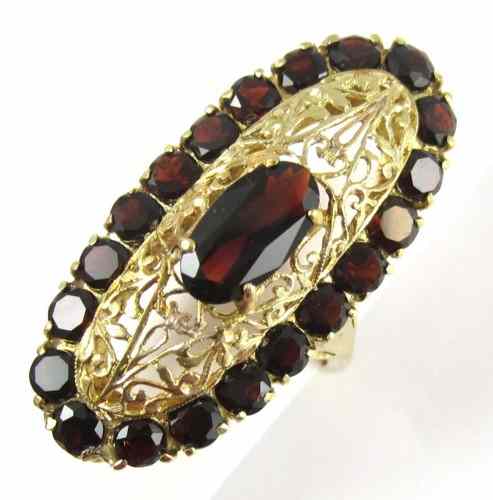 Appraisal: GARNET AND FOURTEEN KARAT GOLD RING set with an oval-cut