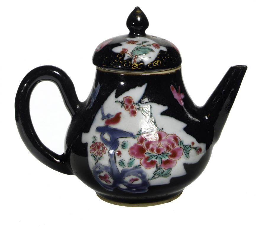 Appraisal: A BLACK GROUND TEAPOT AND COVER enamelled with leaf shaped