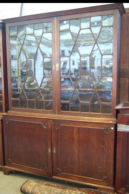 Appraisal: A late th century oak bookcase cupboard the plain cornice